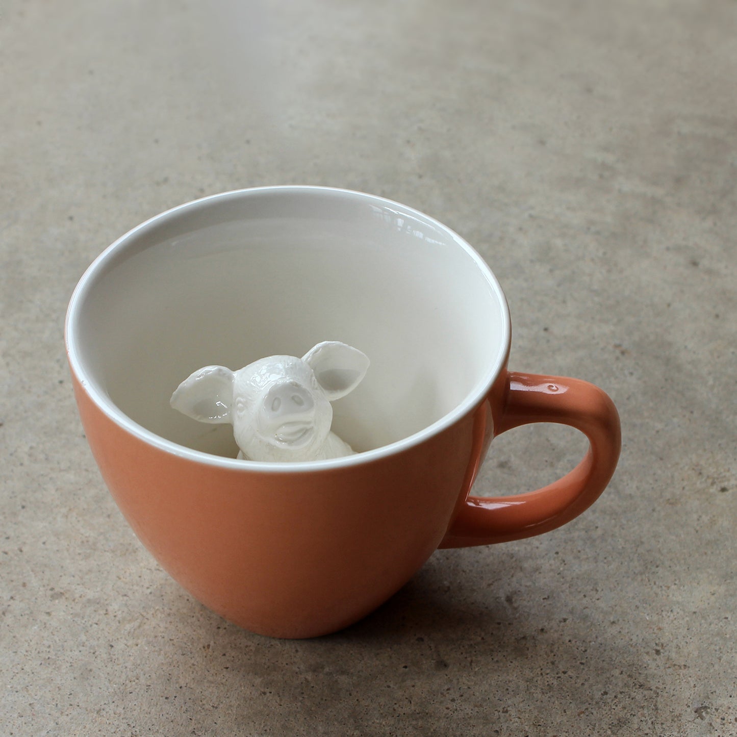 Peach Pig Creature Cup exterior partially submerged on concrete