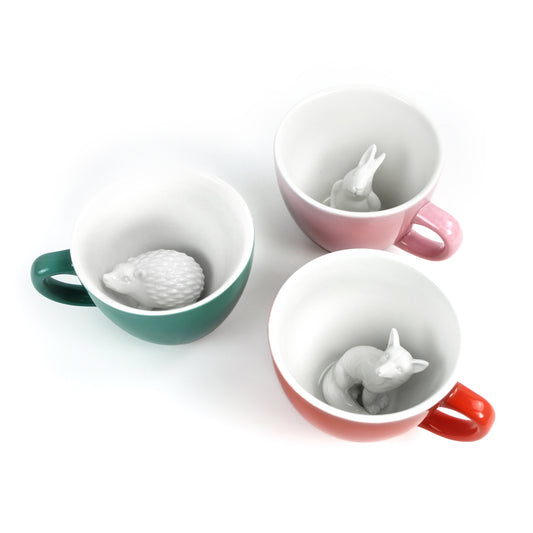 Set of three Creature Cups shown together: blush pink rabbit, aqua green hedgehog, and red orange fox